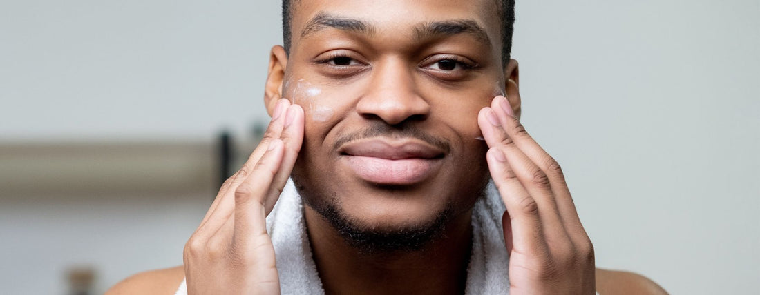black man applying skincare on his face - skin minimalism - DeMay Skin Care